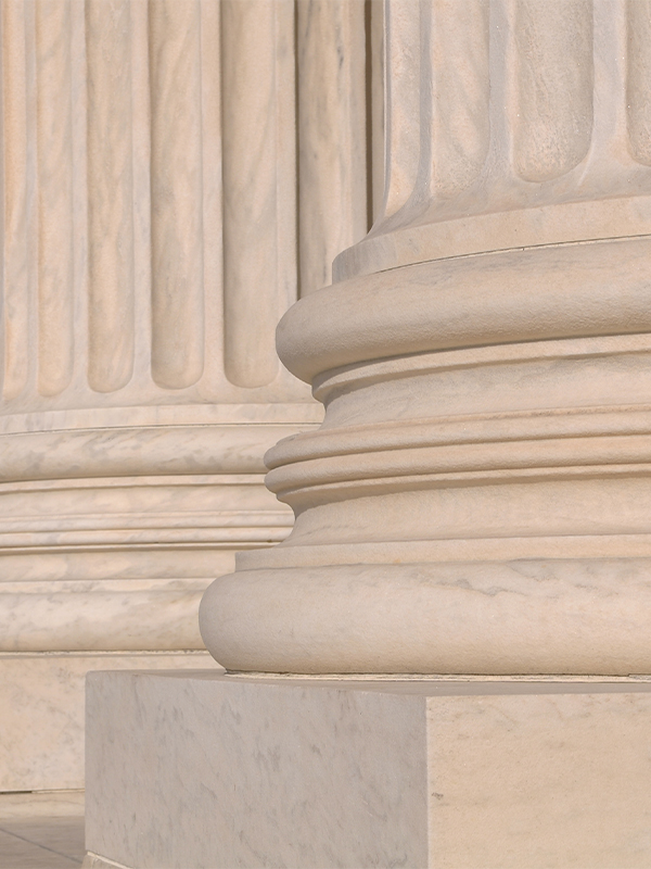 Close-up of the base of a classical column with fluted shaft detailing and a plinth, showcasing neoclassical architecture